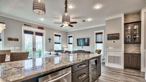 A modern kitchen with granite countertops, stainless steel appliances, and a dining area with a large window.