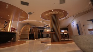 A modern interior with curved wooden structures, a reception area, and a polished floor.