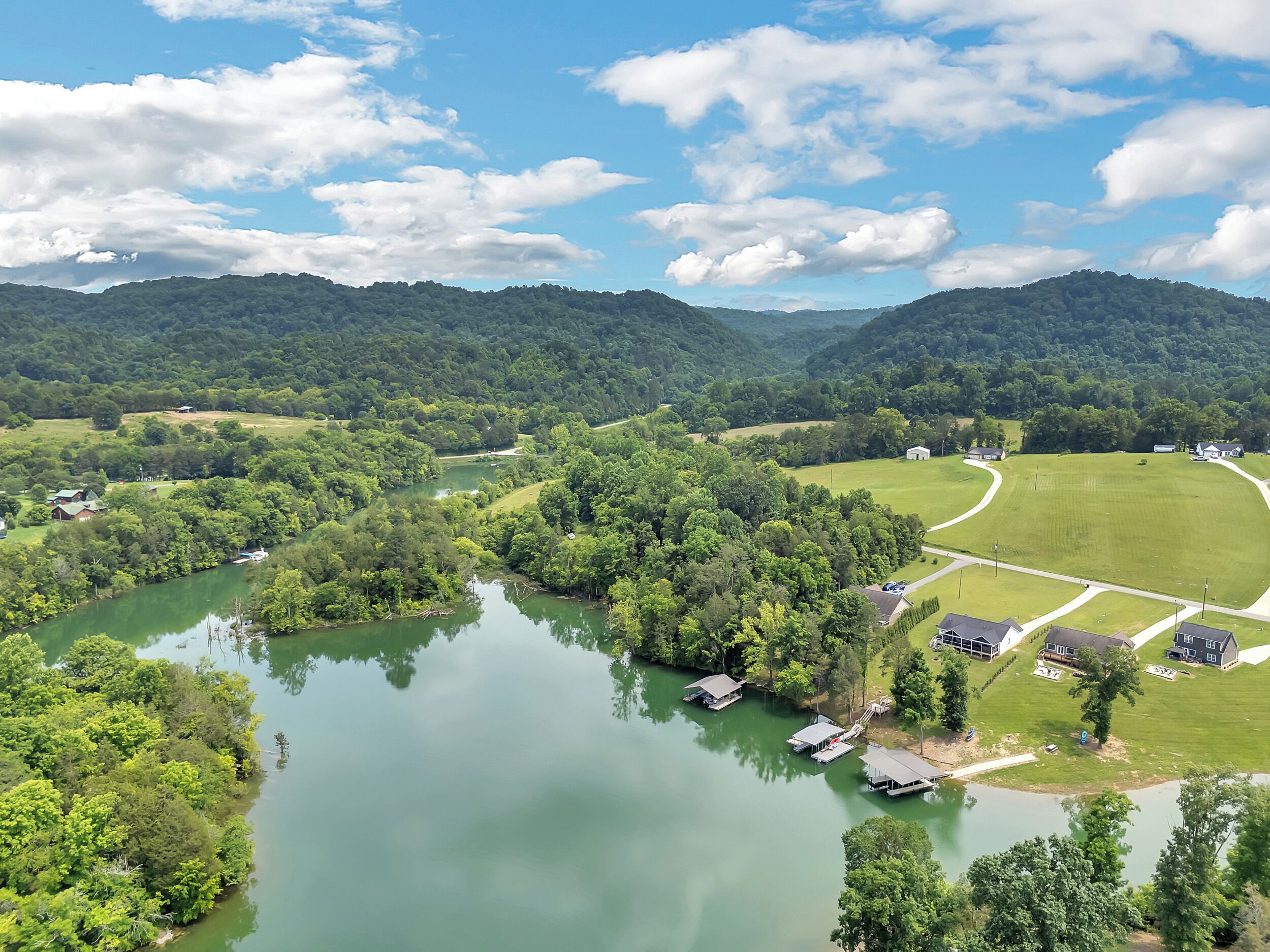 A river with houses and a field.