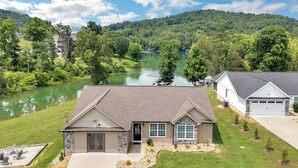 A house with a stone facade, a garage, and a lawn.