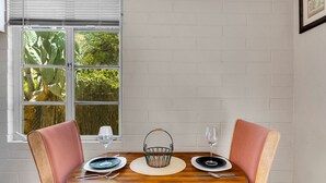 A dining table with four chairs, a basket, and plates and wine glasses. - Tucson Desert Rendezvous (Tucson)