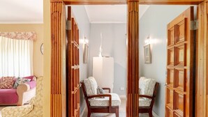 A room with a wooden partition, two armchairs, a sofa, and a white cabinet.