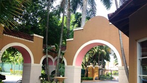 A courtyard with a fountain, arches, and palm trees. - 3bed 2bath Luxury Yatch Club Condo at Aventura Fl, Parking Include! (Miami)