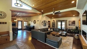 A spacious living area with a large sectional sofa, a dining table, and a kitchen in the background. - Beautiful Private Home W/ Large Living Spaces, Lots of Parking & Close to Trails (Moab)