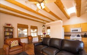 Relax in this inviting living space with a sofa, armchair, and dining area.