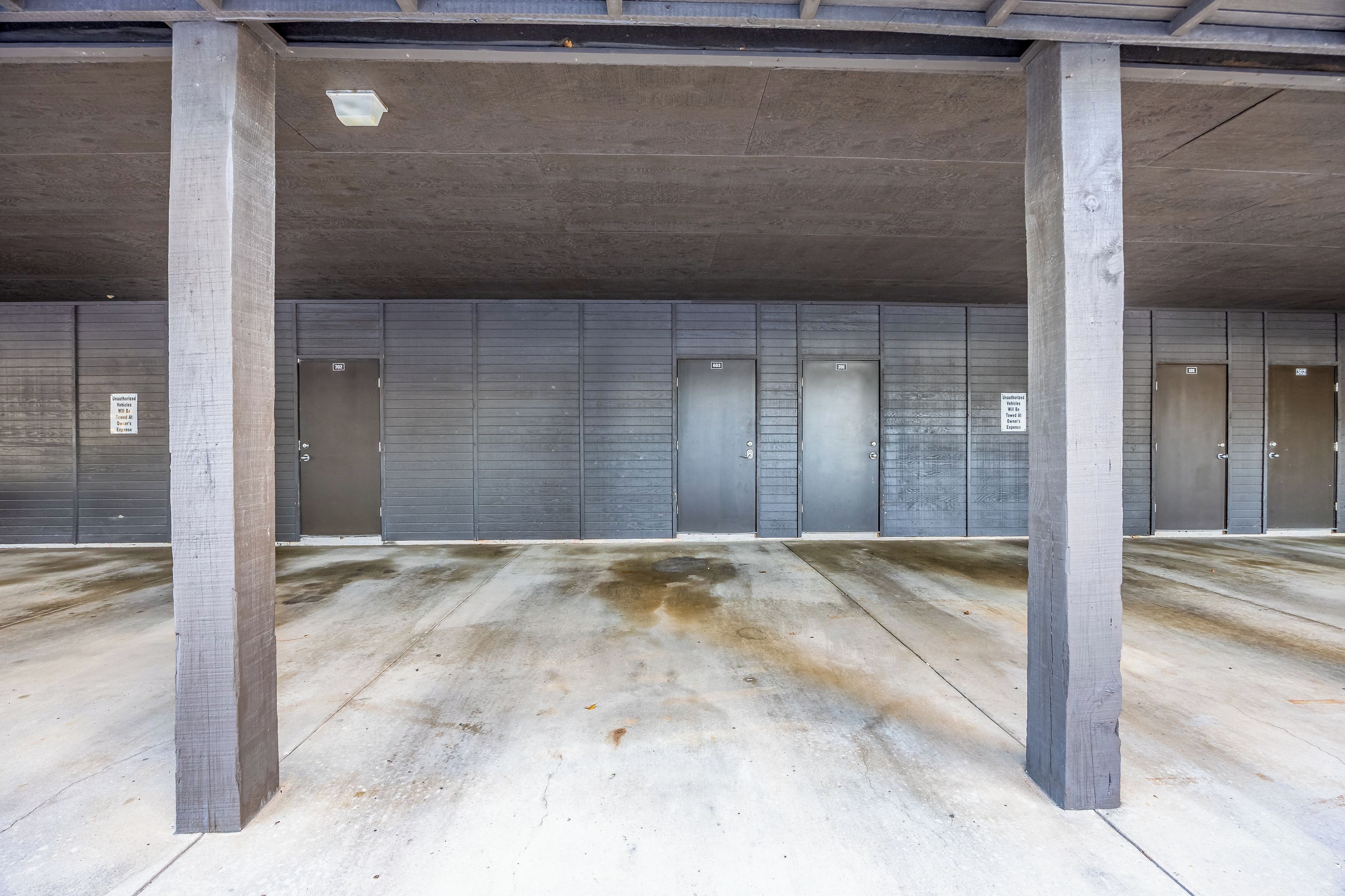 Un bâtiment aux murs gris, doté de nombreuses portes et de piliers en béton.
