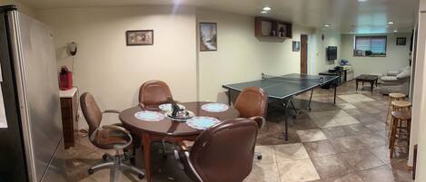 A conference room with a long table, chairs, and a television.
