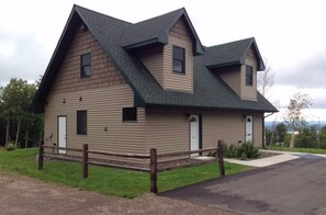 A two-story house with a gabled roof, a front porch, and a fenced yard.
