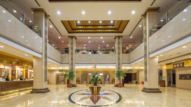 A spacious lobby with a central fountain, multiple floors, and a reception desk.