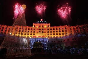 Experience the grandeur of Jiangqu Hotel's classic design, featuring a prominent entrance and beautifully decorated facade.