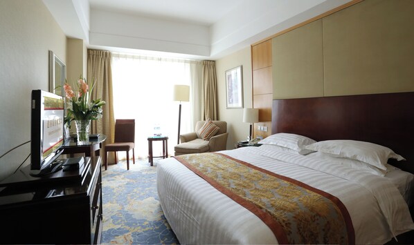 Relax in comfort with a large bed, flat-screen TV, and a cozy armchair.