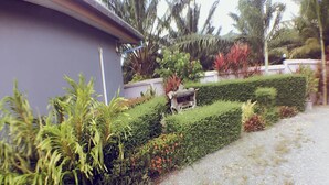 A landscaped garden with a pathway, a statue, and a building. - Numjaan Resort (Krabi)