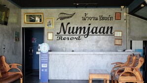 A reception desk at Numjaan Resort with a sign indicating cashless payments preferred. - Numjaan Resort (Krabi)