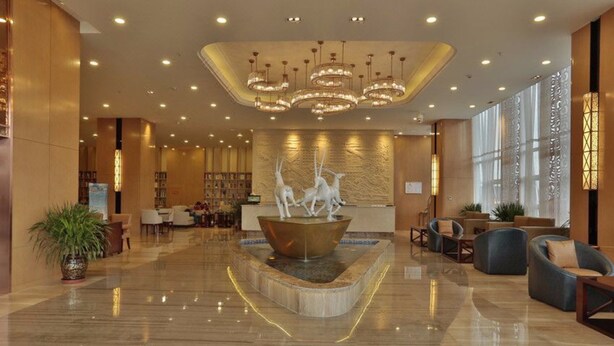 A spacious lobby with a central water feature, a chandelier, and seating areas. - Qinghai Baiyun Xiangling Hotel (Xining)