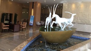 A lobby with a large gold fountain, seating areas, and a reception desk. - Qinghai Baiyun Xiangling Hotel (Xining)