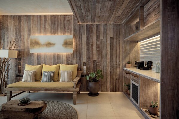 A cozy living room with a wooden sofa, a coffee table, and a fireplace.
