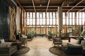 A spacious indoor area with high ceilings, large windows, and a variety of seating arrangements including sofas and chairs. - Dinso Resort & Villas Phuket, Vignette Collection by IHG (Patong)