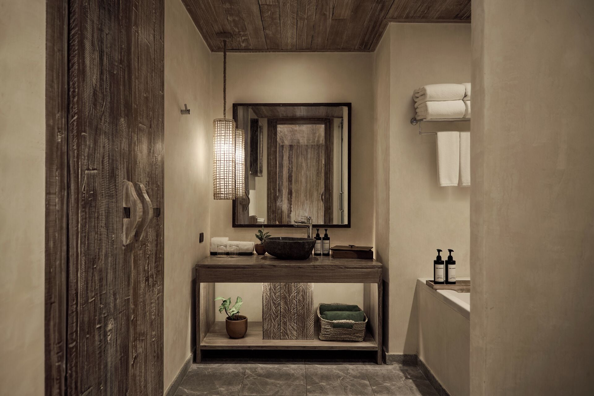 A modern bathroom with a large mirror, a vessel sink, and a wooden vanity.