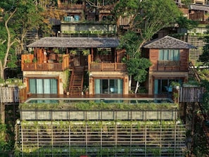 A multi-story house with a glass-bottomed pool, wooden balconies, and a staircase leading to the upper levels. - Dinso Resort & Villas Phuket, Vignette Collection by IHG (Patong)