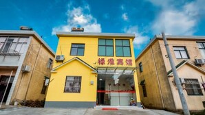 A yellow building with a sign that reads "Hotel". - LuHuai Hotel (Nanjing)
