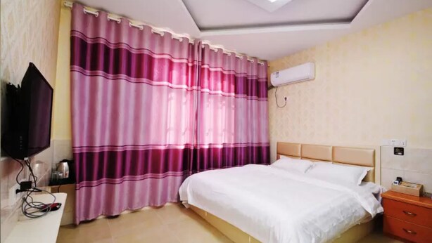 A bedroom with a bed, a TV, a desk, and a nightstand. - LuHuai Hotel (Nanjing)