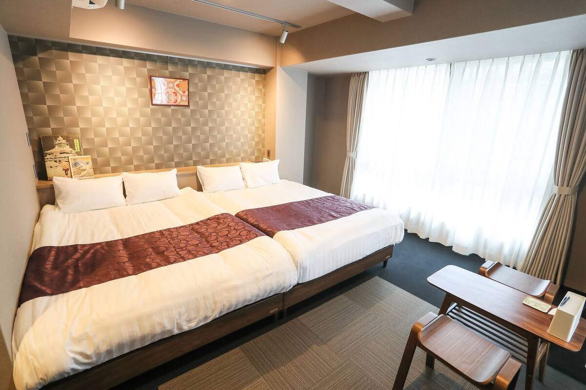 Una habitación de hotel con una cama grande, un escritorio y una silla.