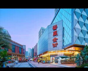 A modern building with large glass windows and a prominent sign with red characters. - Lavender Apartment -Wanda Branch (Guangzhou)
