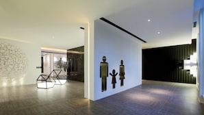 A modern interior with geometric wall art, a dark wooden floor, and a minimalist design.
