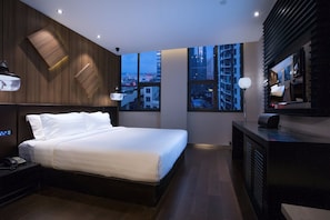 A modern hotel room with a large bed, a desk with a computer, and a city view through large windows. - Crystal Orange Hotel (Qingdao)