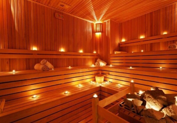 A wooden sauna with benches and candles.