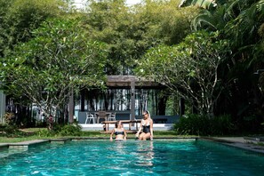 A swimming pool surrounded by lush greenery and a covered seating area. - Isara Khao Lak (Takua Pa)