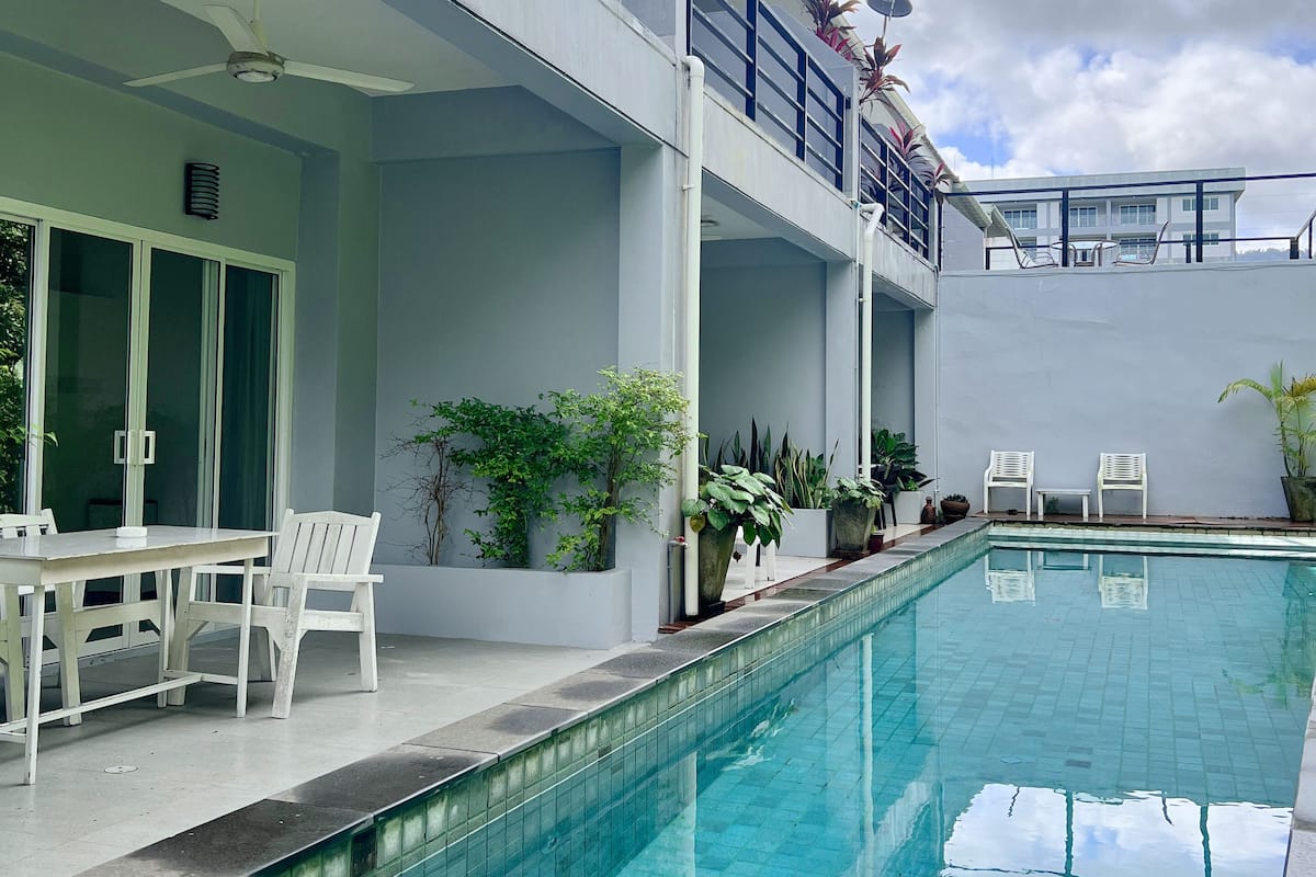 Ein modernes Gebäude mit Pool, Außenbereich und Topfpflanzen.