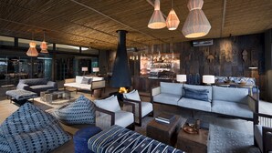 Un espace de détente moderne avec des canapés, une cheminée et un bar.