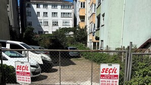 A gated parking area with two signs indicating a contact number for a service. - Amasra Seçil Günlük Kiralık Daire  (Amasra)