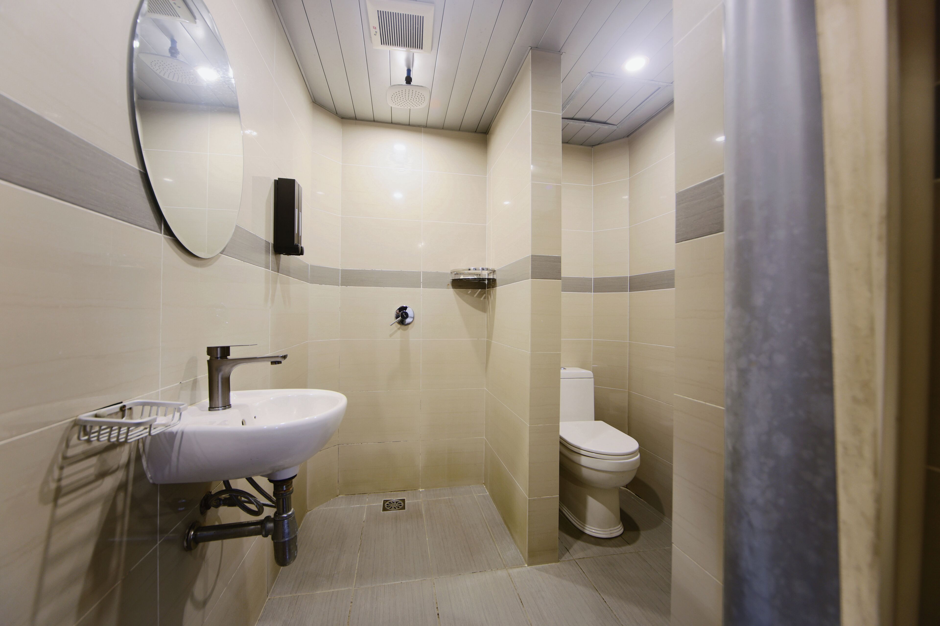 A bathroom with a sink, mirror, toilet, and shower.