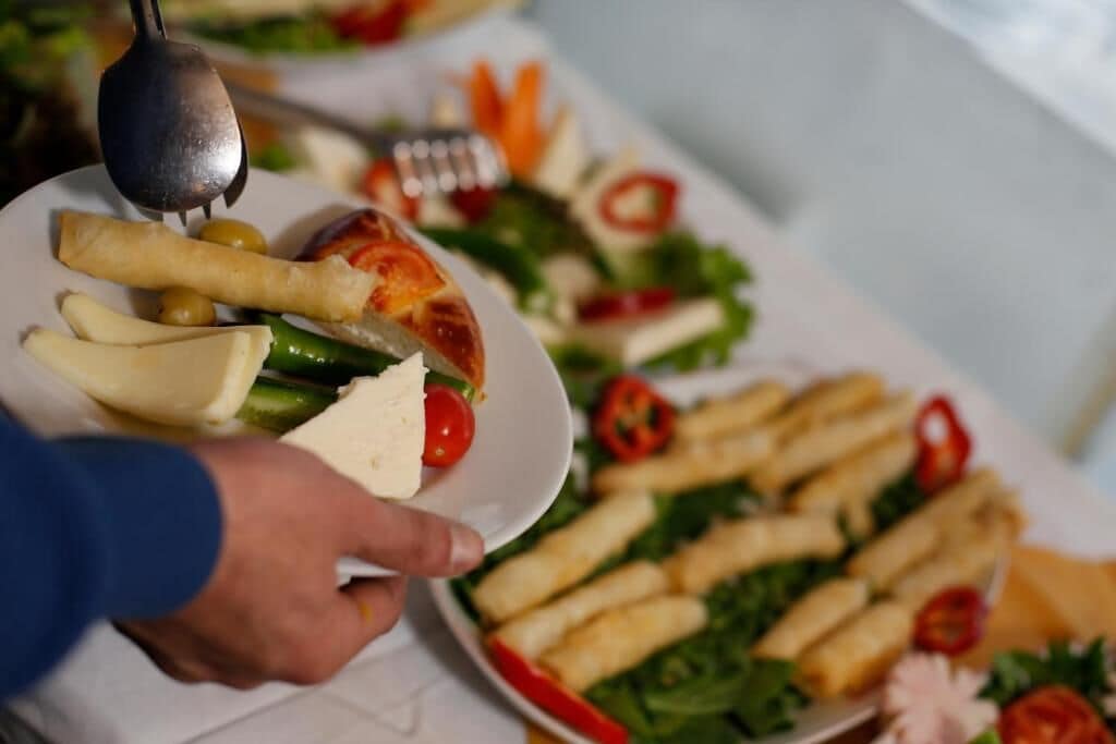 A plate of food including cheese, olives, and vegetables.
