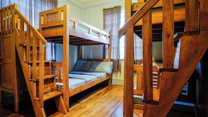 A bunk bed room with wooden railings, a single bed, and a staircase. - Elmar Cabin (Baguio)