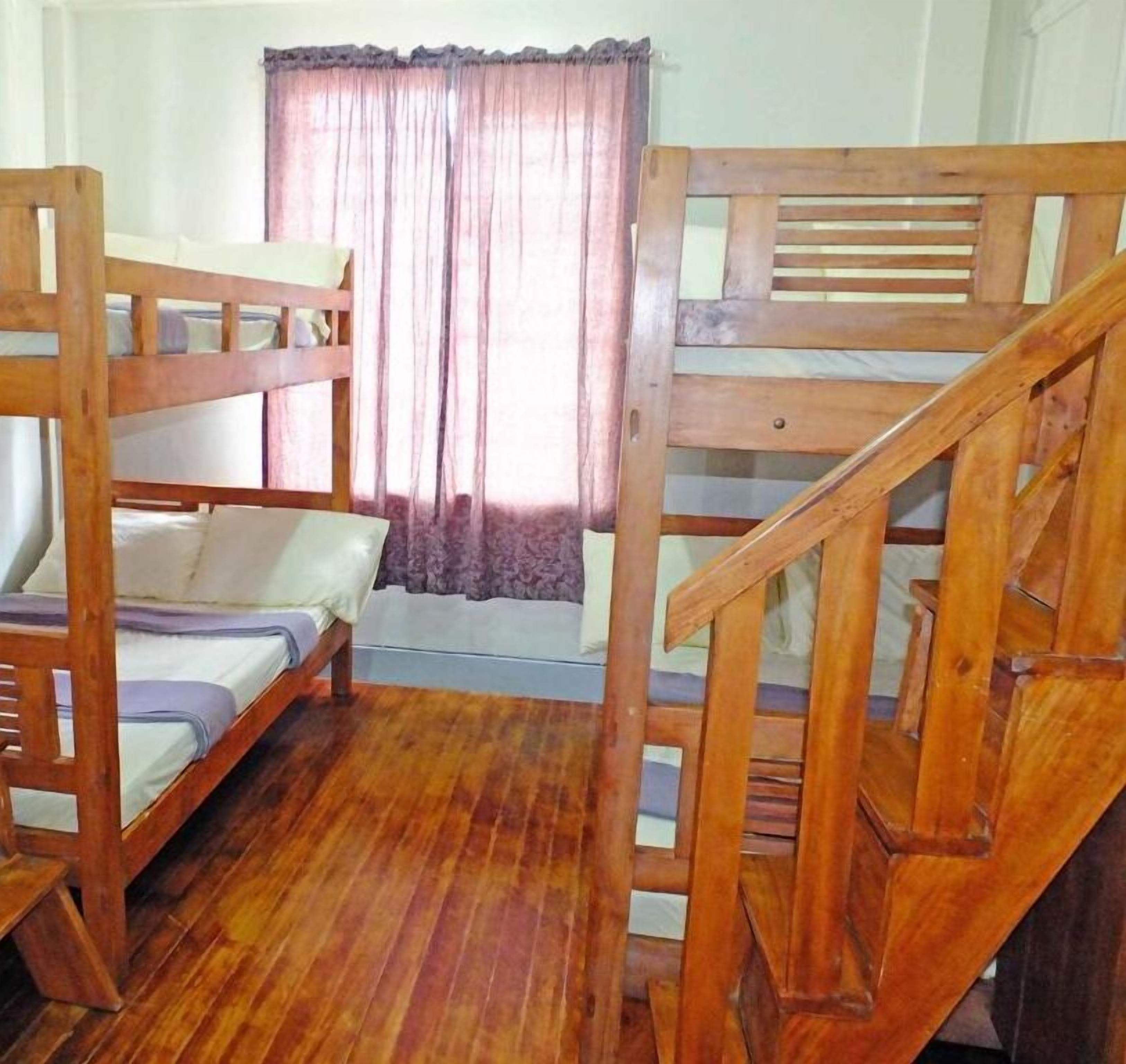 Una habitación con literas y una escalera de madera.