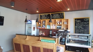 A coffee shop with a wooden counter, espresso machine, and a chalkboard menu. - Elmar Cabin (Baguio)