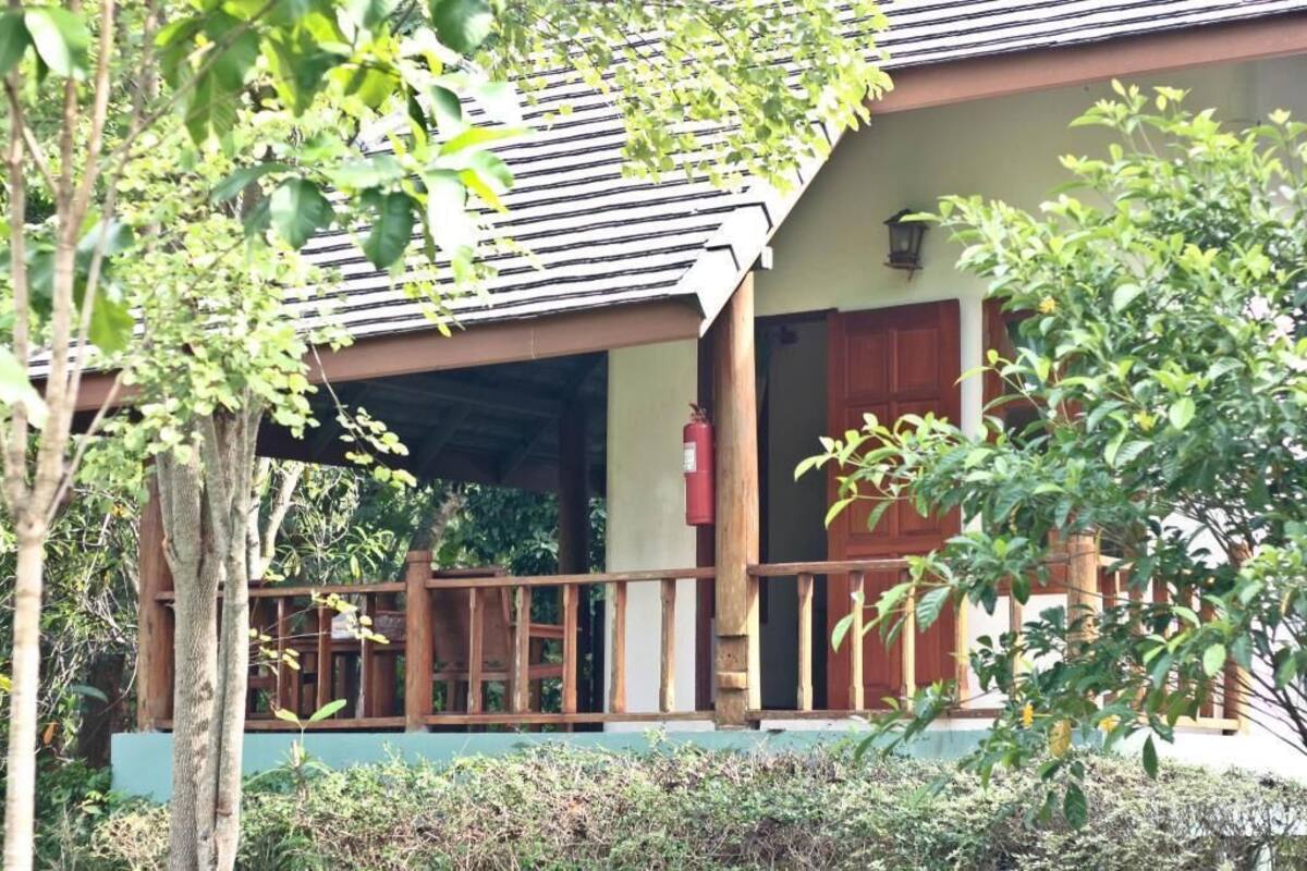 A wooden building with a porch, a fire extinguisher, and a door.