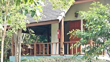 A wooden building with a porch, a fire extinguisher, and a door.