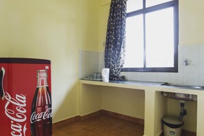 Eine Küche mit Fenster, Spüle und einem Coca-Cola Kühlschrank.
