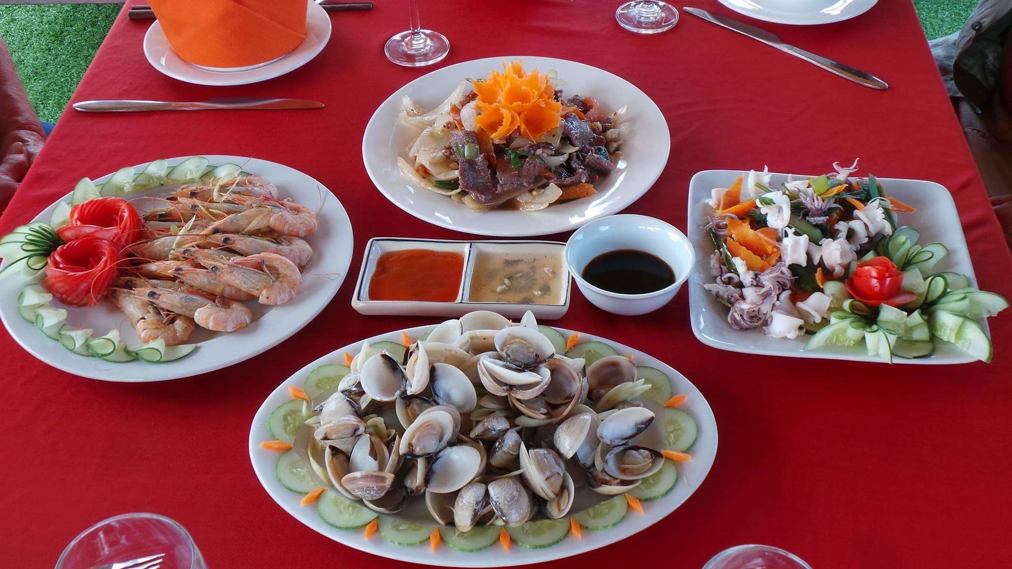 Ein Tisch, reichhaltig gedeckt mit verschiedenen Meeresfrüchten, darunter Garnelen, Muscheln und ein Salat.