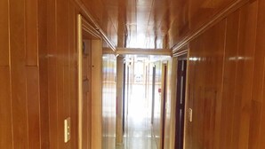 A corridor with wooden paneling and a tiled floor. - Ocean Cruise (Hai Phong)