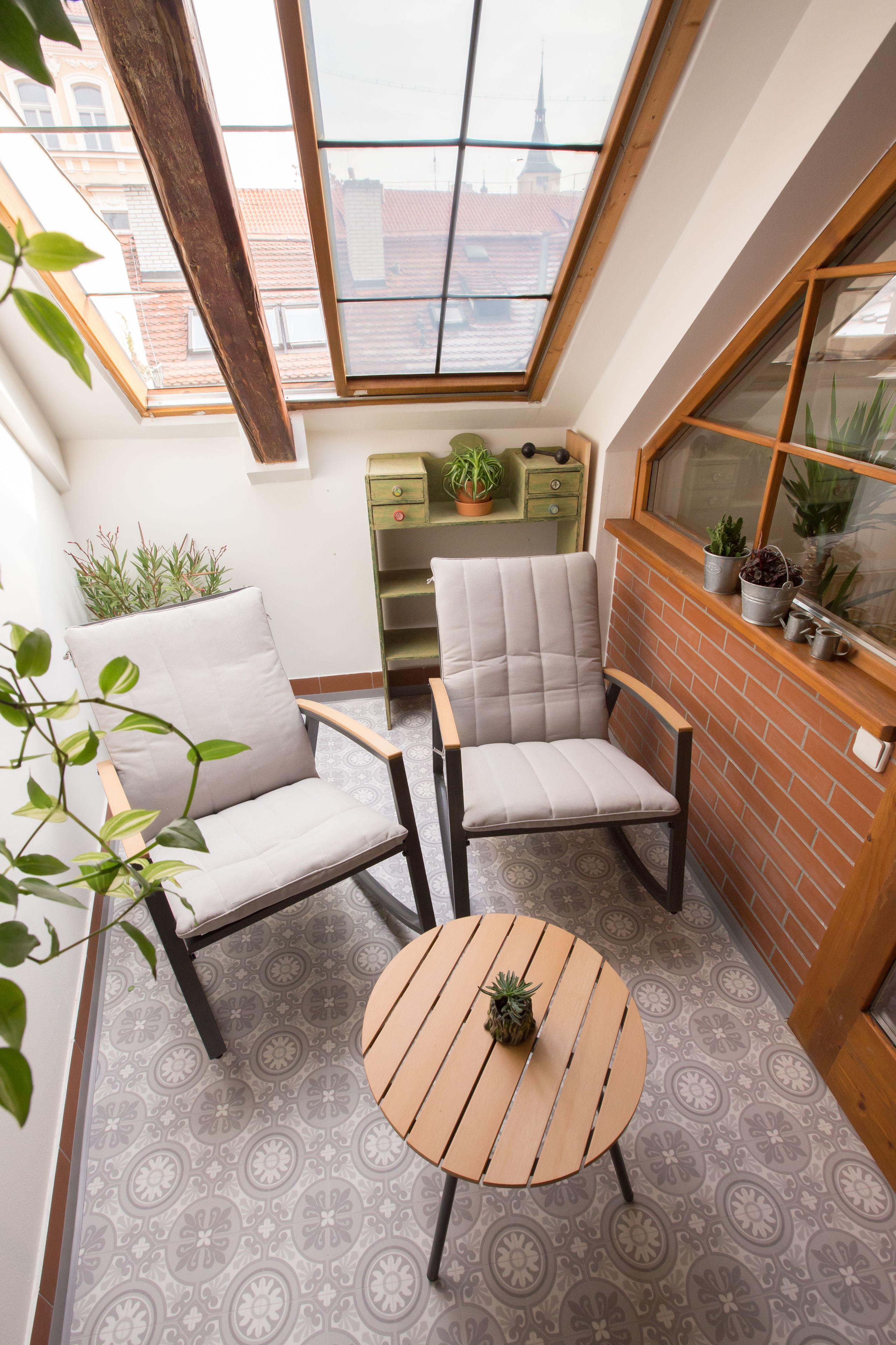 Una habitación acogedora con dos sillones, una mesita redonda y vistas a través de un tragaluz.