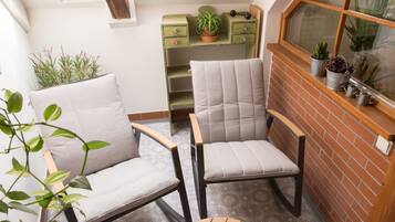 Una habitación acogedora con dos sillones, una mesita redonda y vistas a través de un tragaluz.