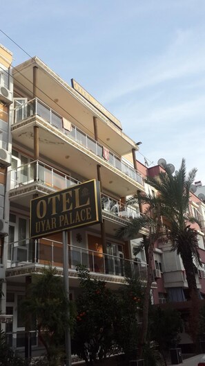 A multi-story building with balconies and a sign for "OTEL UYAR PALACE". - Uyar Palace (Antalya)