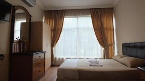 Ein Hotelzimmer mit einem Bett, einem Schminktisch, einem Spiegel und einem Fernseher.