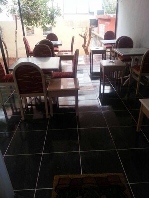 A restaurant with tiled flooring and wooden tables and chairs. - Uyar Palace (Antalya)