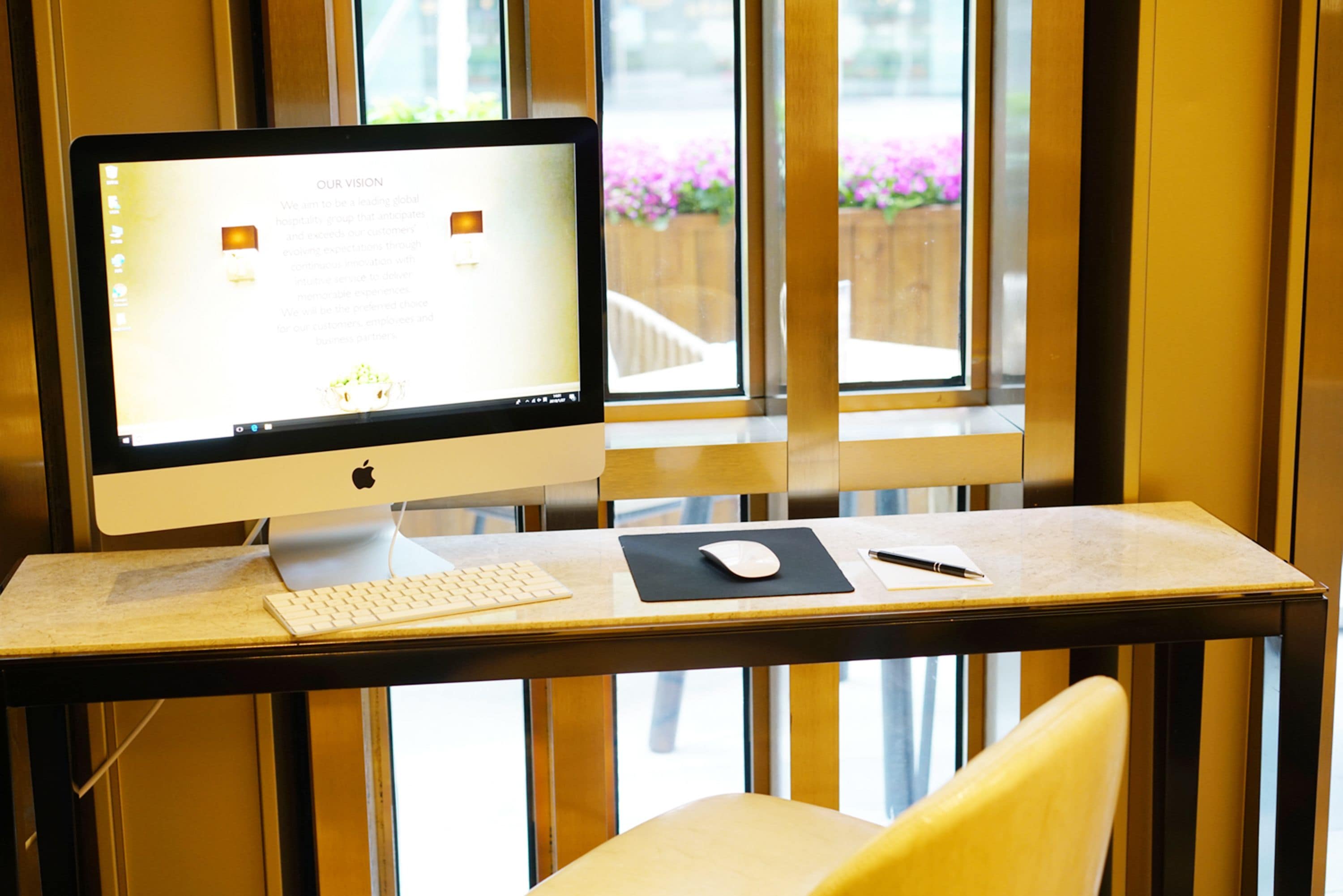 Un espacio de trabajo moderno con una computadora de escritorio, teclado, ratón y una silla.
